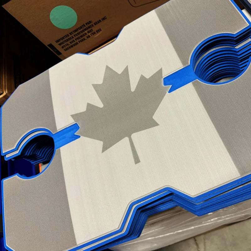 Load image into Gallery viewer, Stack of custom-cut silver and blue metal sheets featuring a maple leaf design
