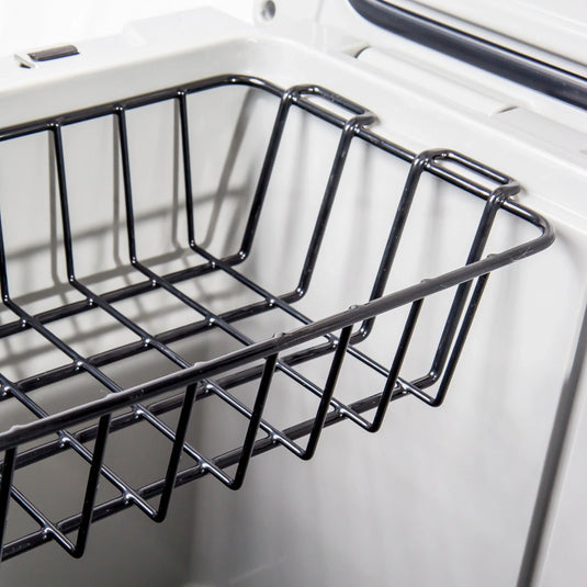 Black metal wire storage basket inside a white freezer or refrigerator compartment