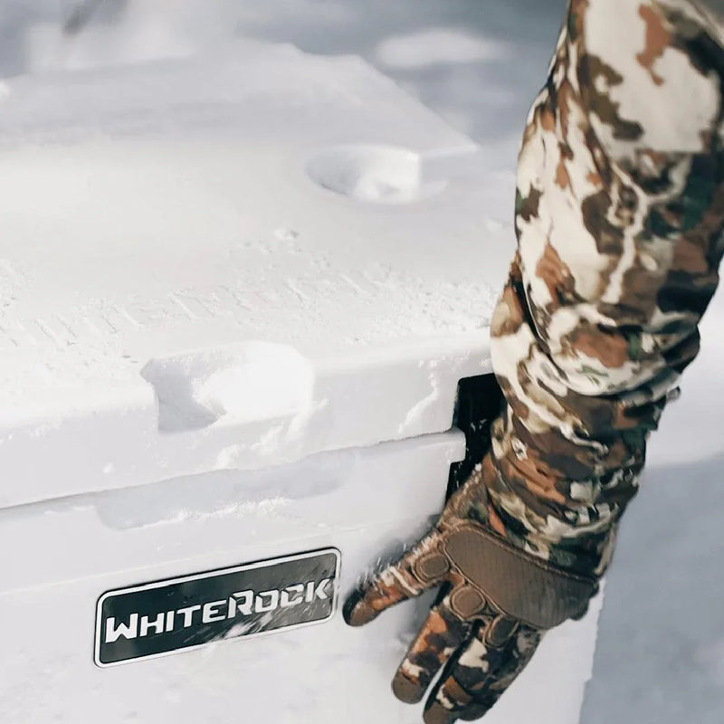 Load image into Gallery viewer, Person in camouflage glove opening snow-covered WhiteRock cooler outdoors
