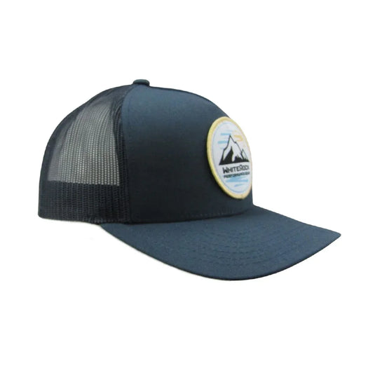 Blue trucker cap with mesh back and round patch featuring mountain design and text